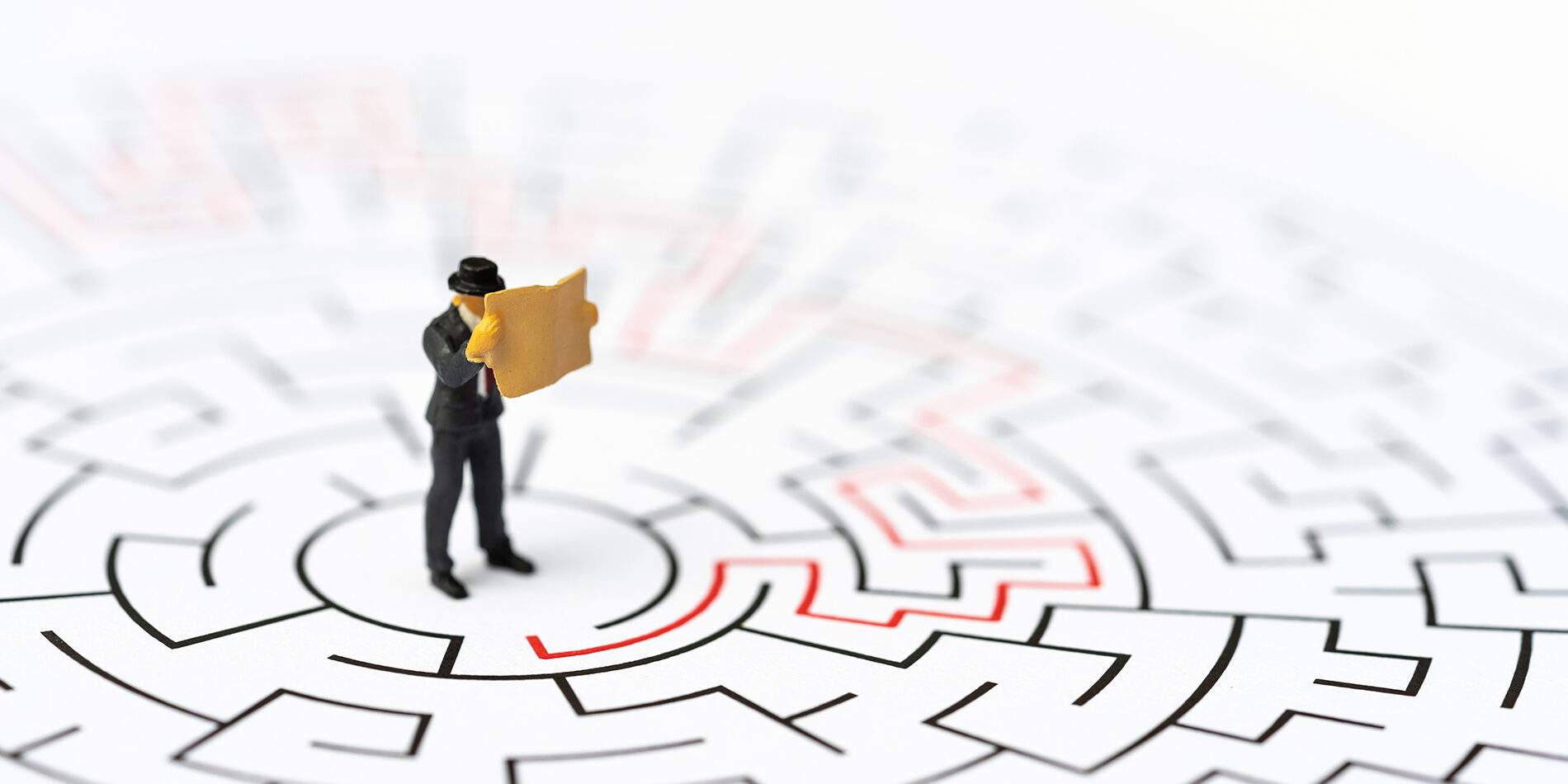 Miniature people, businessman in the labyrinth or maze figuring